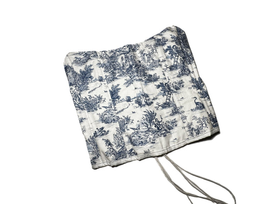 Trägerlose Corsage aus weißer Baumwolle mit blauem Toile-de-Jouy-Muster, verlängerter Schnitt und Rückenschnürung.